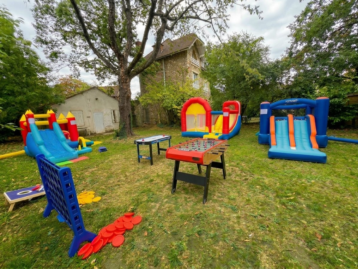 Châteaux gonflables, baby-foot et jeux géants dans un jardin pour une kermesse